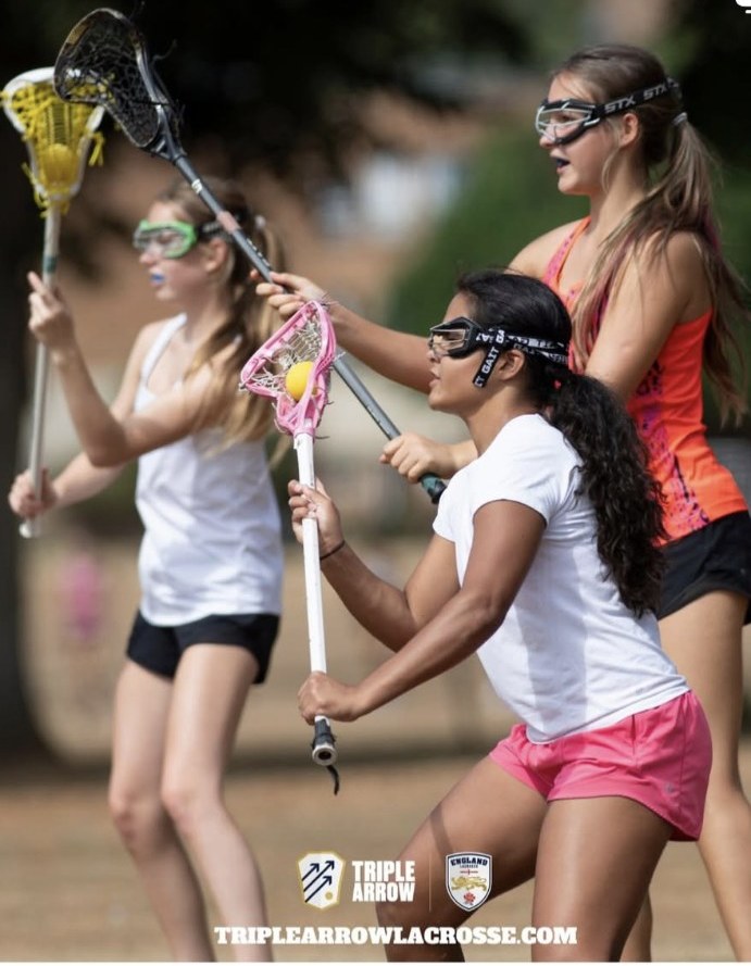 A younger Freya Larson with the ball in her pink stick at a Triple Arrow Lacrosse camp in England