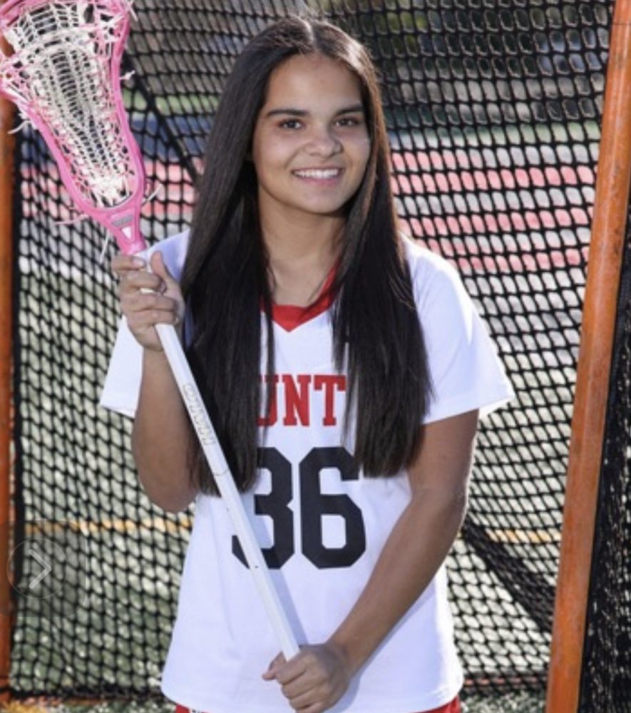 Freya Larson in her Mount Si uniform, number 36, holding her lacrosse stick in front of the goal