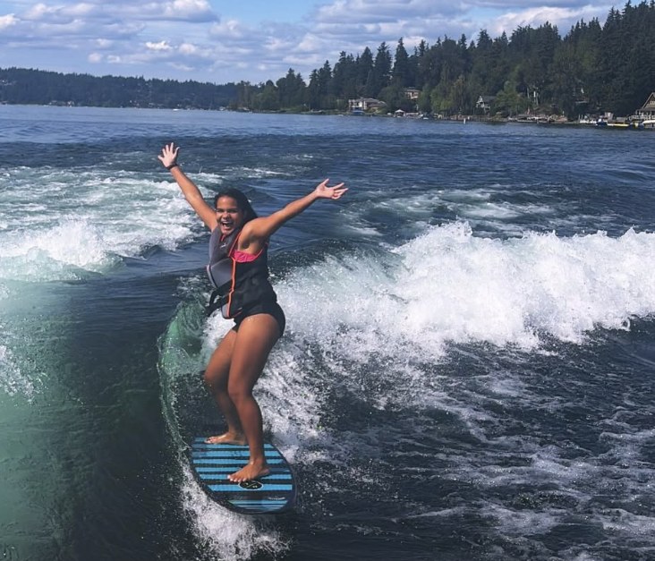 Freya Larson wakesurfing on Lake Sammamish, arms out, riding the wake